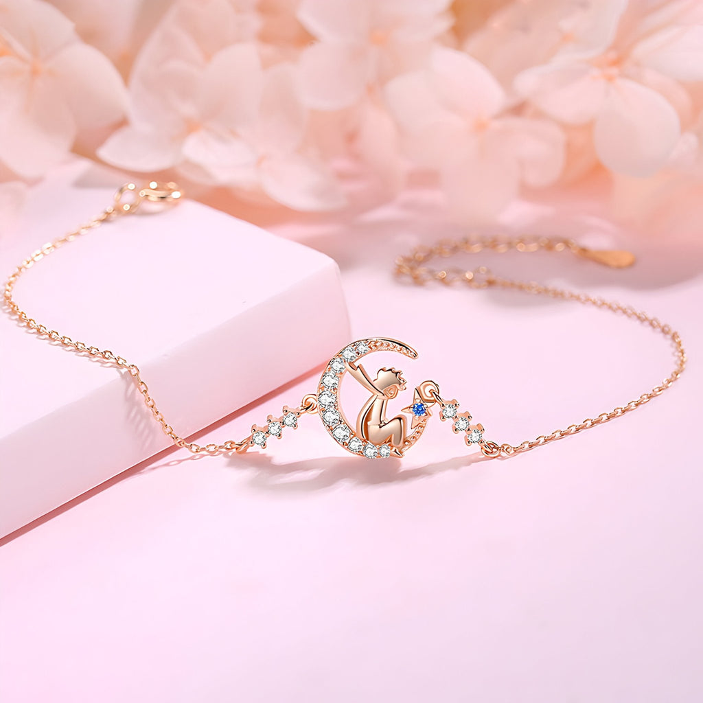 Bracelet en or rosé avec pendentif petit prince orné de pierres scintillantes sur chaîne fine.