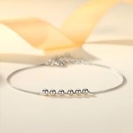 Bracelet fin en argent sterling avec cinq petites perles rondes brillantes sur chaîne délicate.