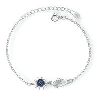 Bracelet en argent sterling avec pendentif soleil noir orné de cristaux bleus et nuage délicat.
