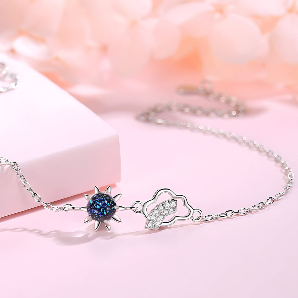 Bracelet argent sterling avec pendentif soleil noir et nuage stylisé sur chaîne fine.