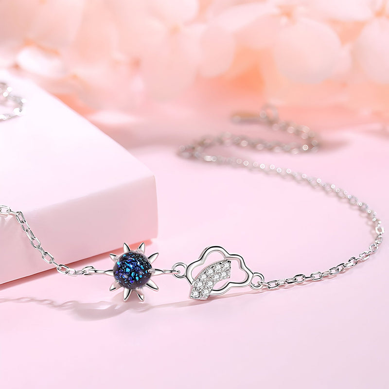 Bracelet argent sterling avec pendentif soleil noir et nuage stylisé sur chaîne fine.