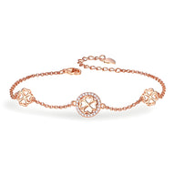 Bracelet fin en or rosé avec trois breloques trèfle à quatre feuilles ajourées en argent sterling.