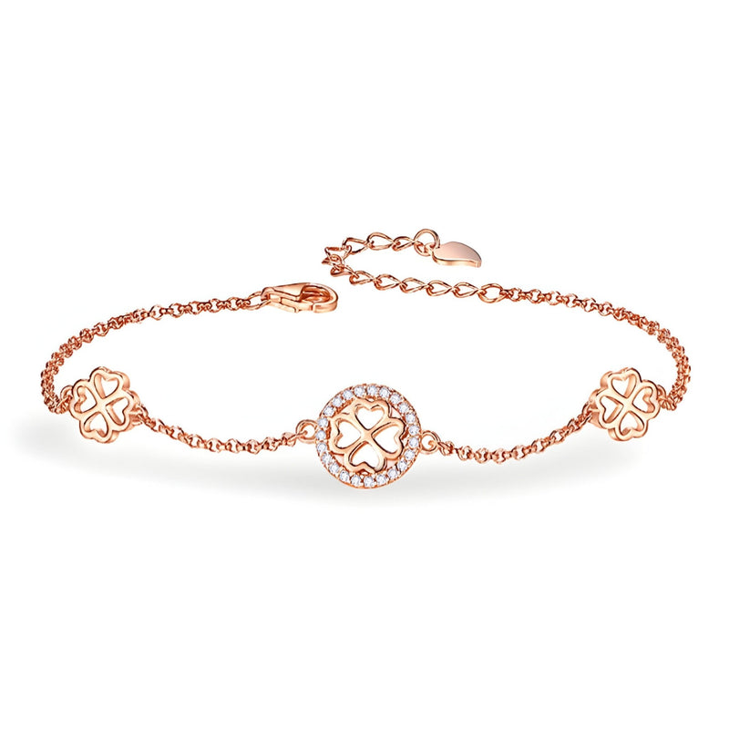 Bracelet fin en or rosé avec trois breloques trèfle à quatre feuilles ajourées en argent sterling.