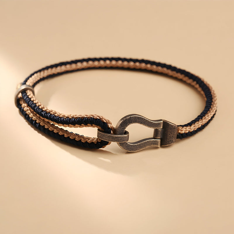 Bracelet unisexe noir et argent en cordon tressé avec fermoir en forme de fer à cheval.