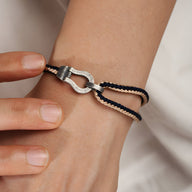 Bracelet en argent sterling avec cordon noir et fermoir en forme de fer à cheval, style unisexe.