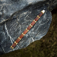Bracelet masculin en bois d'acajou marron avec détails métalliques dorés, style moderne et naturel.
