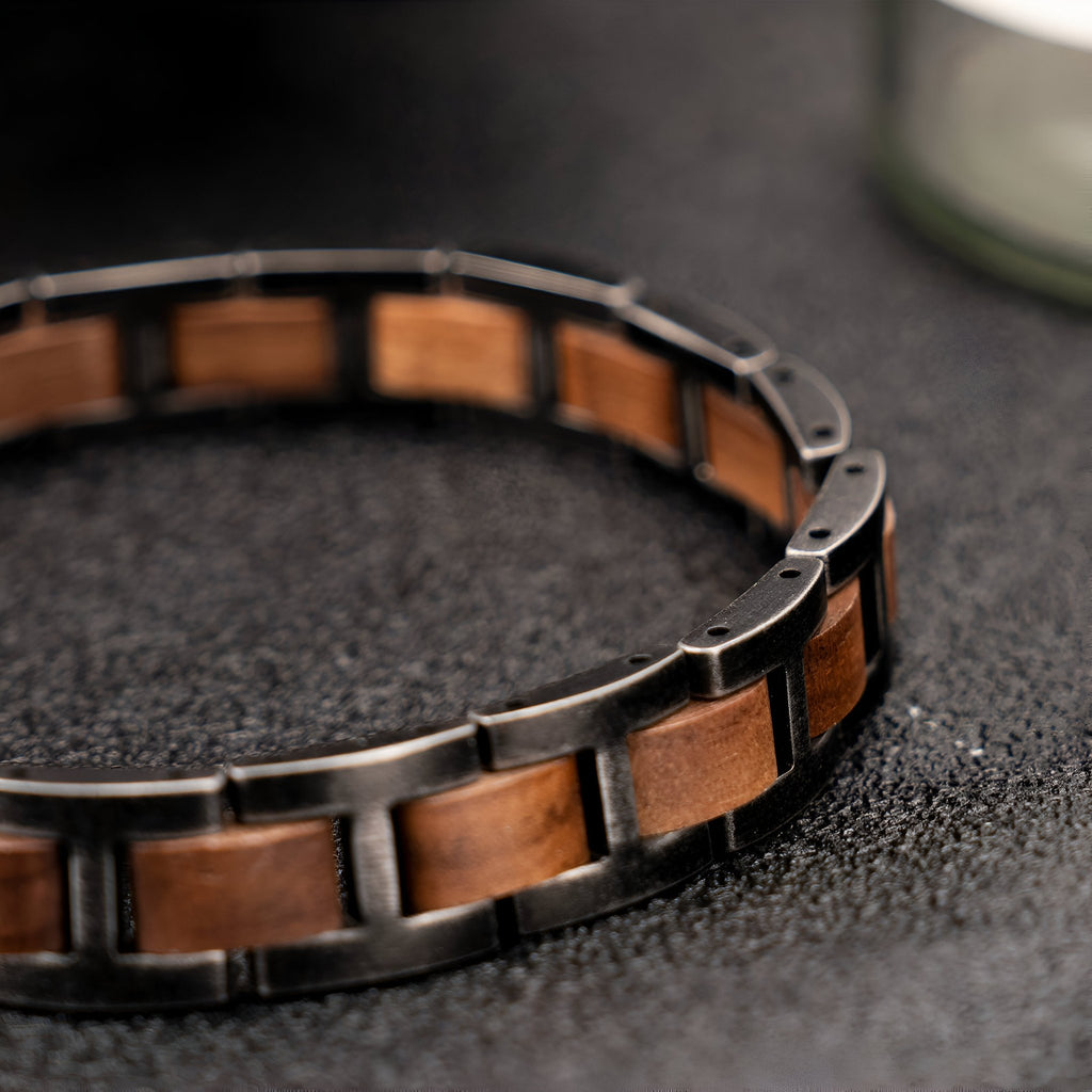 Bracelet pour homme en bois de noyer marron avec maillons noirs en métal, style naturel et moderne.