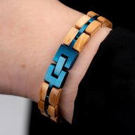 Bracelet en bois de noyer beige avec éclats bleus métallisés et maillons géométriques bleus.