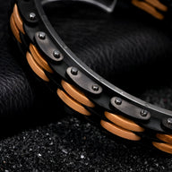 Bracelet pour homme en bois de noyer marron et noir avec rivets métalliques sur cuir noir texturé.