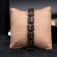 Bracelet homme en bois de noyer sombre avec maillons rectangulaires reliés par des chaînes métalliques noires.