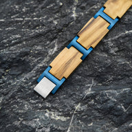 Bracelet en bois d'olivier beige et bleu pour homme avec maillons rectangulaires et fermoir métallique gris.
