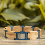 Bracelet homme en bois d'olivier beige avec liens et fermoir bleu métallique élégant.