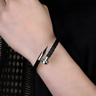Bracelet en cuir noir tressé avec extrémité conique en métal argenté, style moderne masculin.