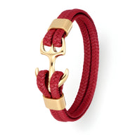 Bracelet en cuir rouge tressé avec ancre dorée et fermoir assorti, style marin élégant.