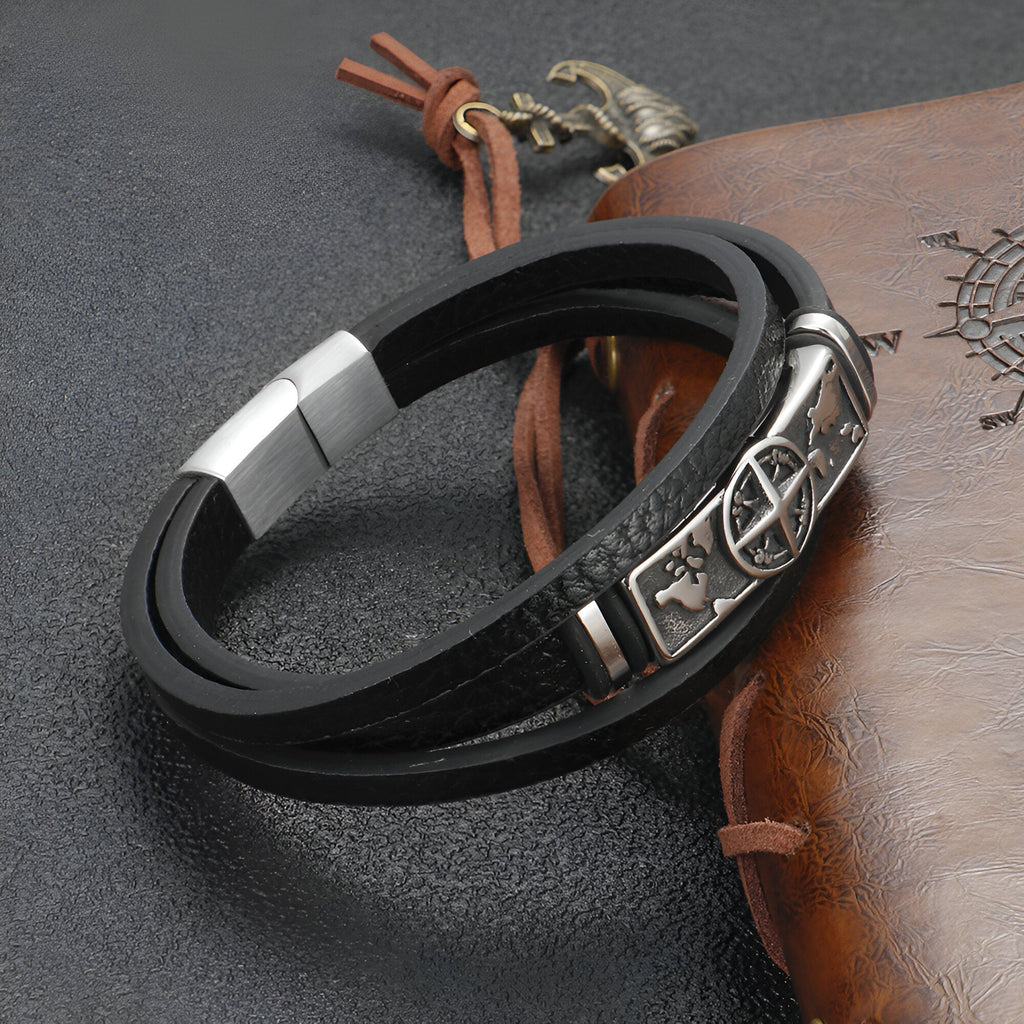Bracelet en cuir noir à double tour avec motif boussole en métal argenté et fermoir magnétique.