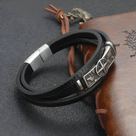 Bracelet en cuir noir à double tour avec motif boussole en métal argenté et fermoir magnétique.