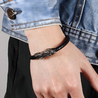Bracelet en cuir noir avec motif tête de dragon métallique et fermoir décoratif.