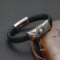 Bracelet en cuir noir tressé avec plaque métal argentée tête de mort ailée et fermoir magnétique.