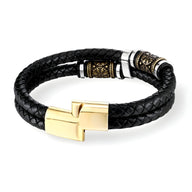 Bracelet en cuir noir tressé avec fermoir doré et détails viking gravés sur métal noir.