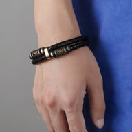 Bracelet en cuir noir double tour avec motif viking doré et fermoir métallique élégant.