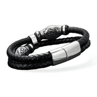 Bracelet en cuir noir tressé double tour avec détails métalliques gravés style viking et fermoir argenté brillant.