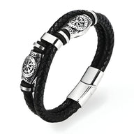 Bracelet en cuir noir tressé avec motifs vikings en métal argenté et fermoir magnétique lisse.