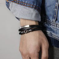 Bracelet homme multi-rangs en cuir noir avec motif tressé et détail métal argenté.