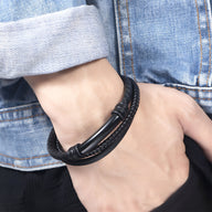 Bracelet en cuir noir tressé élégant avec fermoir noir mat, style masculin moderne.