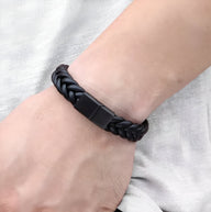 Bracelet homme en cuir noir torsadé avec fermoir noir mat, style moderne et épuré.
