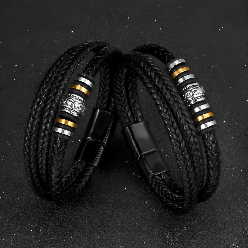 Bracelet homme noir en cuir tressé avec motif métallique argenté et détails dorés, fermeture aimantée noire.