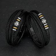 Bracelet homme noir en cuir tressé avec motif métallique argenté et détails dorés, fermeture aimantée noire.