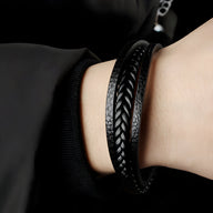 Bracelet homme noir en cuir tressé et cuir lisse avec fermeture métallique argentée.