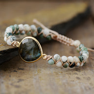 Bracelet multi-rangs en labradorite bleue et blanche encerclée d’or, avec perles de tourmaline tressées sur cordon beige.