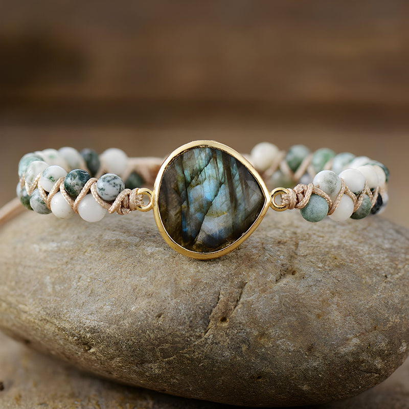 Bracelet multi-rangs en labradorite bleue irisée et tourmalines blanches monté sur fil doré.