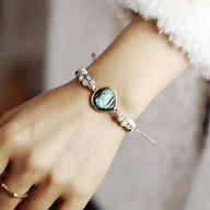 Bracelet multi-rangs en labradorite bleu irisé et perles blanches, style féminin élégant.