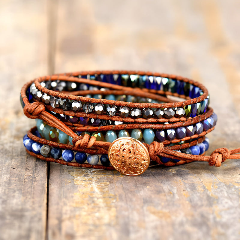 Bracelet multi-rangs pour femme en lapis lazuli bleu, hématite argentée, sur cordon cuir marron avec bouton gravé en métal.