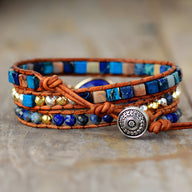 Bracelet multi-rangs en lapis lazuli, jaspe bleu, perles dorées, cuir marron et fermoir bouton argenté décoré.