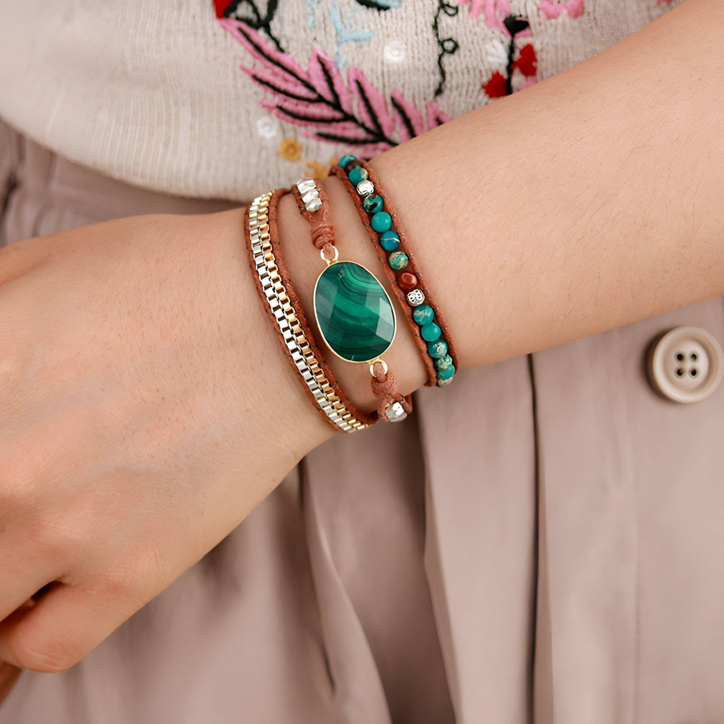 Bracelets multi-rangs avec malachite verte, perles de jaspe marron et détails dorés sur poignet féminin.
