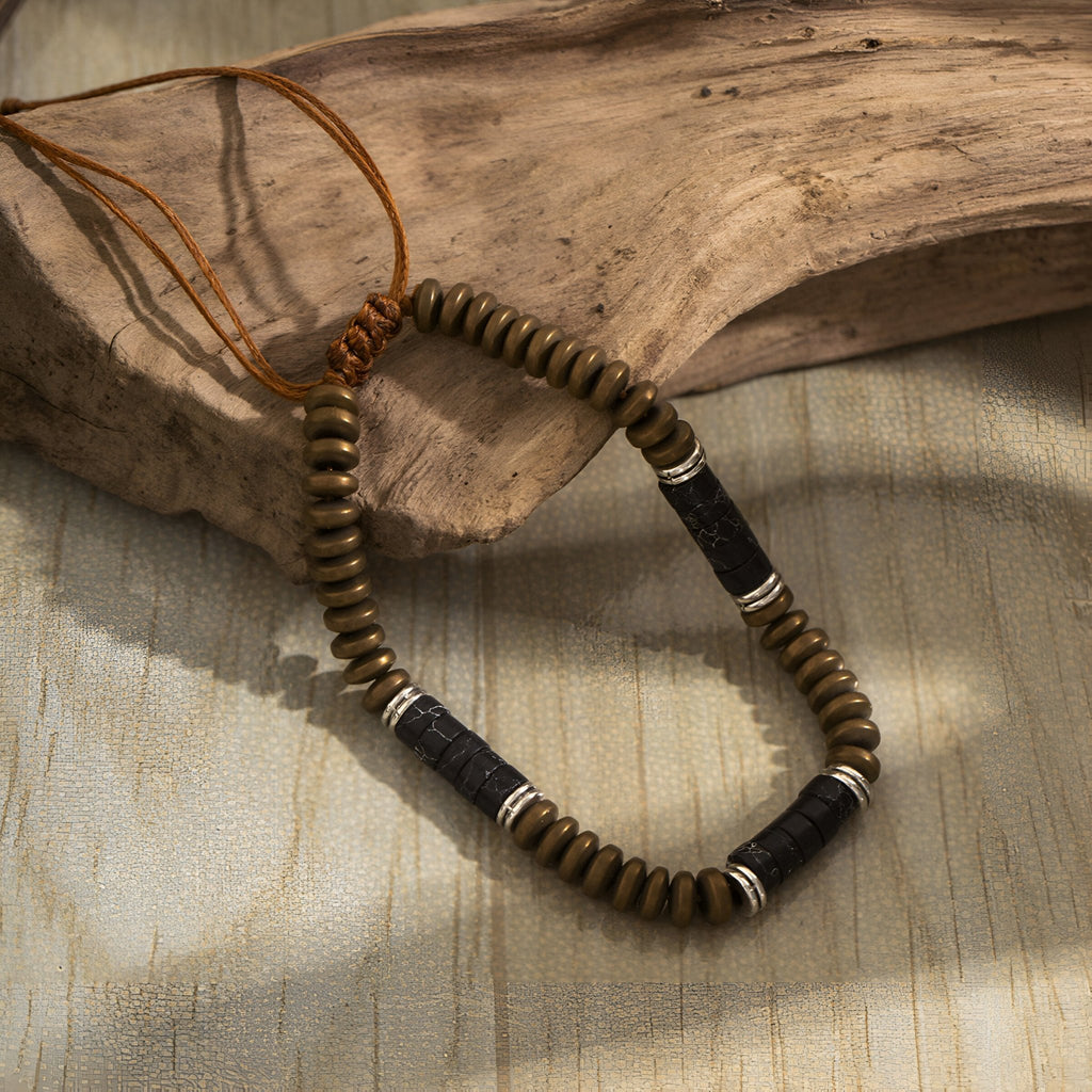 Bracelet homme en perles marron et cylindres noirs en métal avec finition artisanale.
