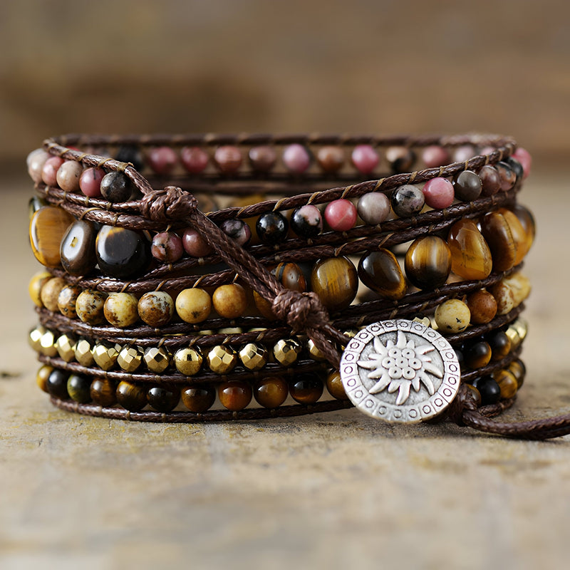 Bracelet multi-rangs marron en œil de tigre et rhodonite avec breloque soleil argentée.