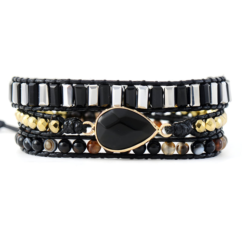 Bracelet multi-rangs noir en onyx, perles noires, cuivre doré et détail goutte centrale lisse.