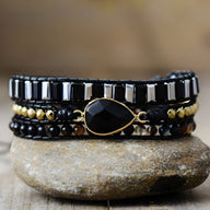 Bracelet multi-rangs femme en onyx noir et perles cuivre avec pendentif goutte noir au centre.