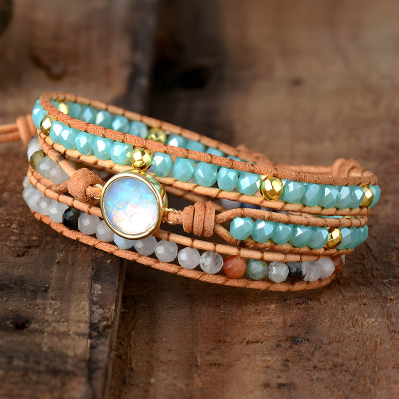 Bracelet multi-rangs en cuir avec perles turquoise, gris, blanc et or, ornement central en opale scintillante.
