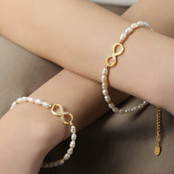 Bracelet femme en perles naturelles blanches avec motif infini doré serti de zircones.