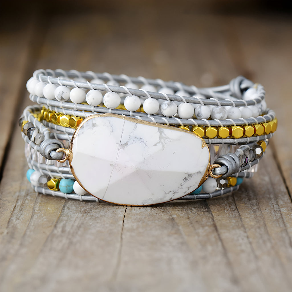 Bracelet multi-rangs en pierre d'howlite blanche avec perles dorées et tressage gris clair.