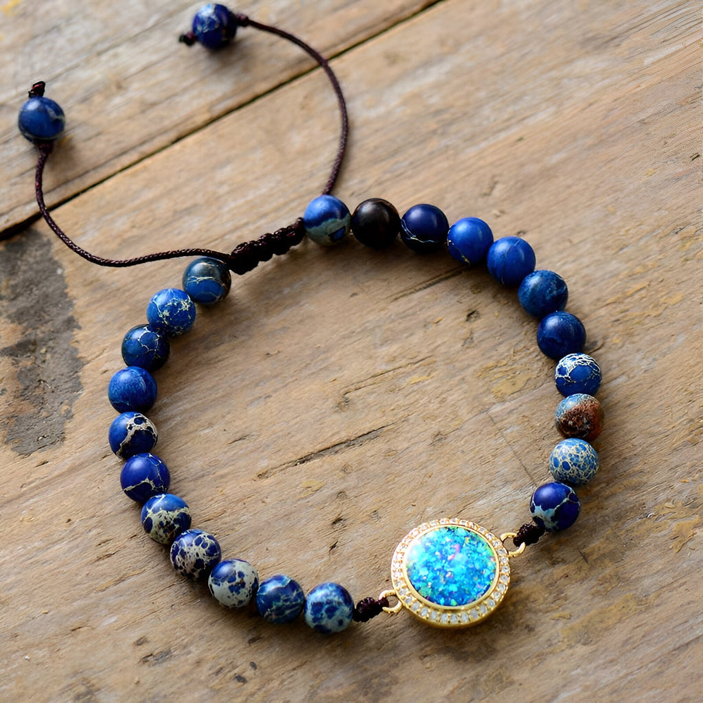 Bracelet femme multirang perles de jaspe bleues et opale centrale ronde sertie or sur cordelette noire ajustable.