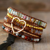 Bracelet multi-rangs en pierres de jaspe multicolores avec cœur métallique doré central sur cuir marron.