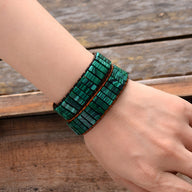 Bracelet multi-rangs en pierres de malachite verte sur cordon noir ajustable.