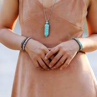 Bracelet multi-rangs en pierres turquoise et perles naturelles porté sur poignet féminin.