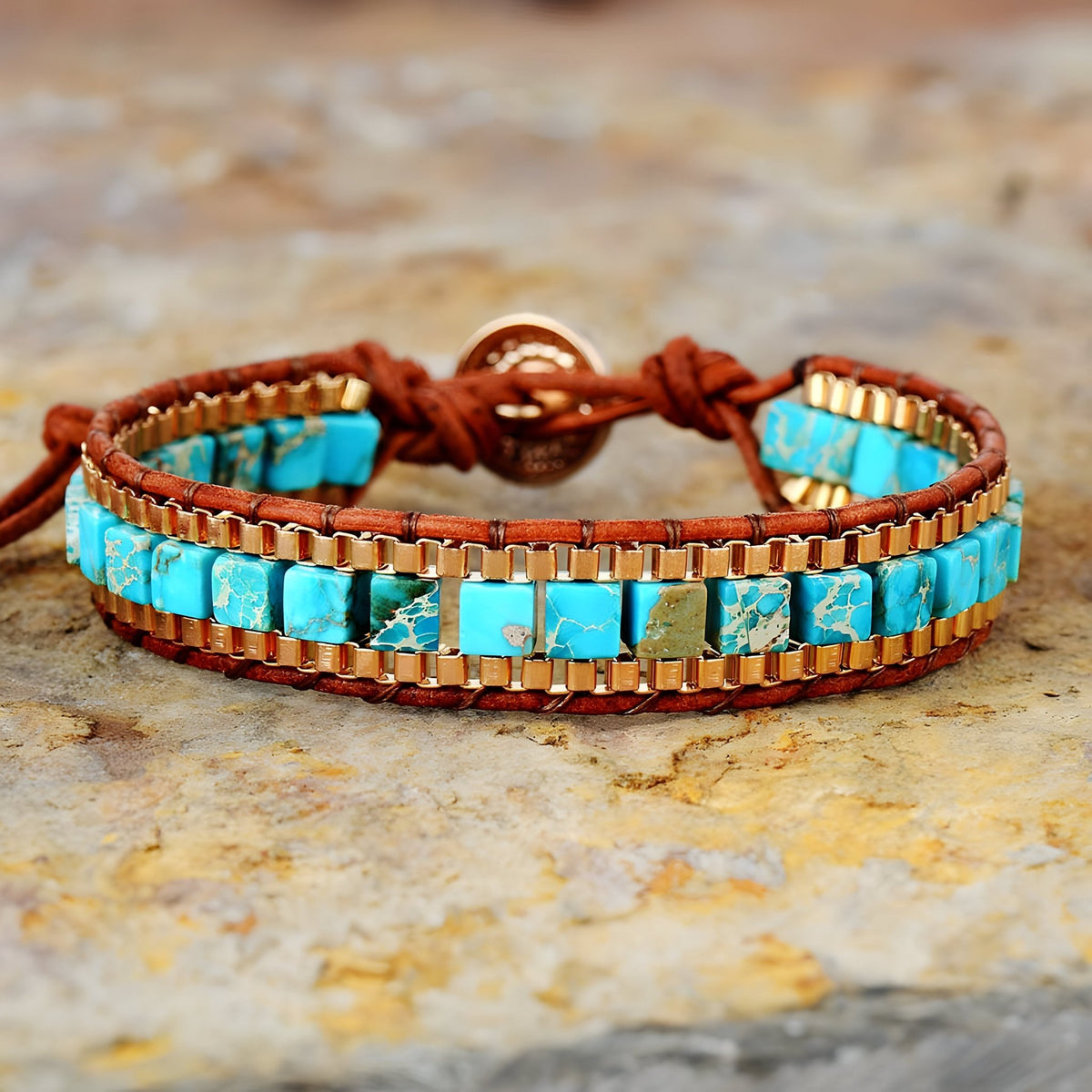 Bracelet multi-rangs en pierres turquoise carrées montées sur cuir marron avec fermoir bouton en cuivre.